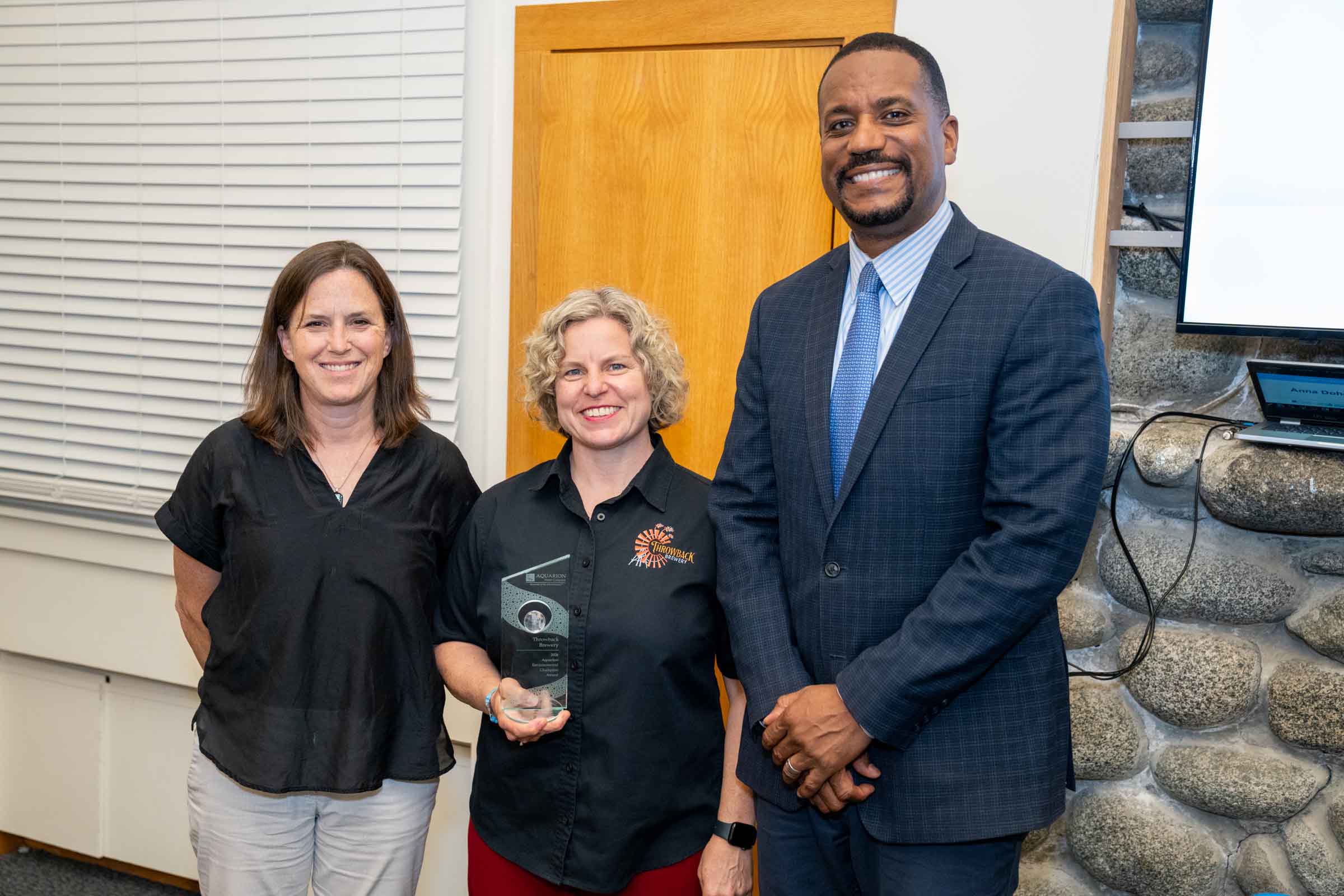 throwback-brewery-business Nicole Carrier, co-founder and president of Throwback Brewery poses with her award. Next to her are Jen Kennedy of Blue Ocean Society and George Logan of Aquarion.