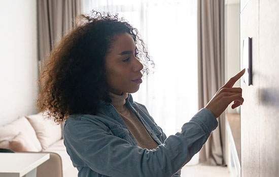 woman using digital thermostat