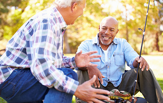 two seniors laughing with fishing poles